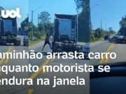 Homem se pendura na janela para agredir motorista enquanto caminhão arrasta carro; veja