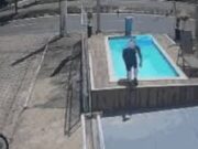 Motociclista mergulha com capacete em piscina de loja para se refrescar no calor